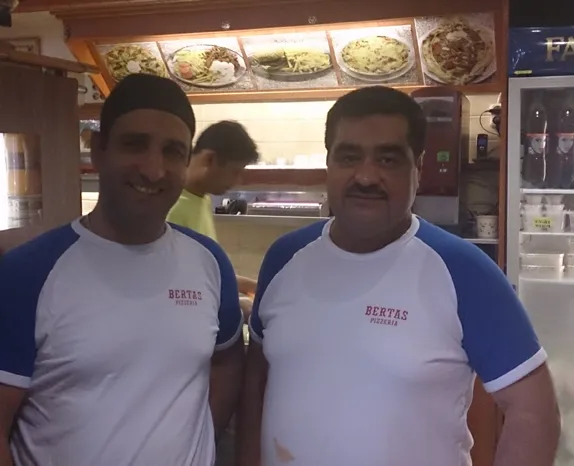 Två av oss på Bertas Pizzeria i Bertas-tröjor framför disken